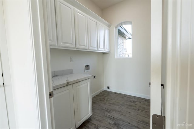 clothes washing area with cabinets, washer hookup, and dark wood-type flooring