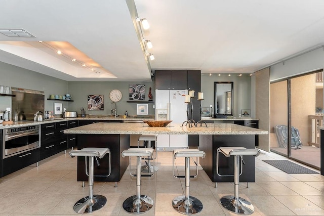 kitchen featuring a kitchen bar, rail lighting, and stainless steel oven