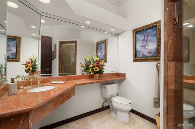 full bath featuring toilet, a sink, a shower stall, baseboards, and tile patterned floors