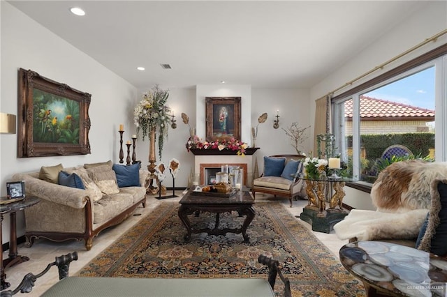 living area featuring a fireplace, light colored carpet, visible vents, and recessed lighting