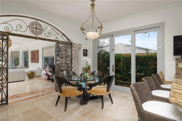 dining area featuring crown molding and ornate columns