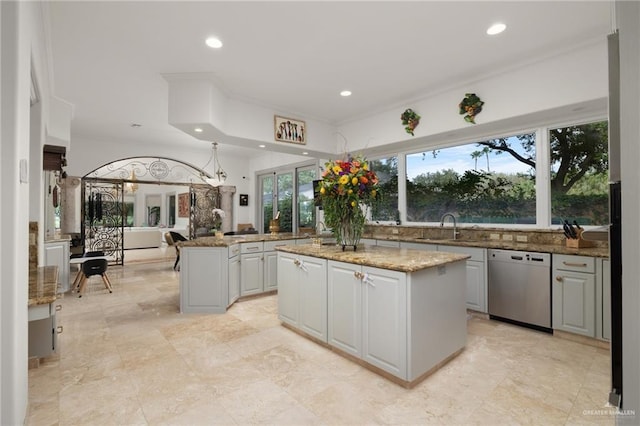 kitchen featuring dishwasher, a center island, stone counters, a sink, and recessed lighting