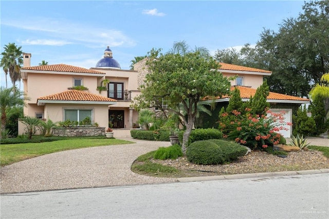 view of front of home featuring a garage, concrete driveway, a tile roof, and stucco siding