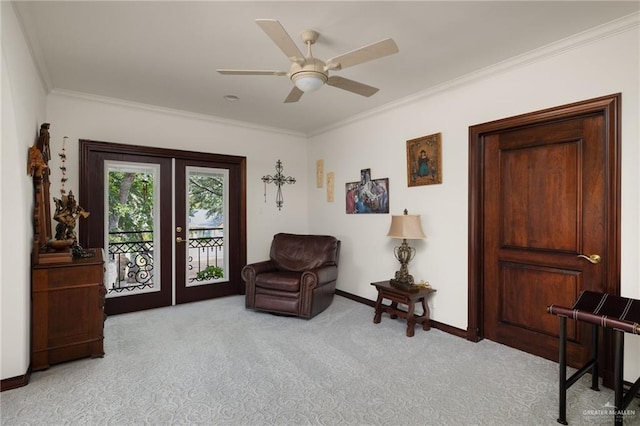 sitting room with ceiling fan, light carpet, baseboards, french doors, and crown molding