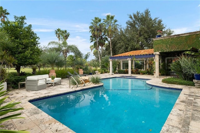 outdoor pool with a patio and outdoor lounge area