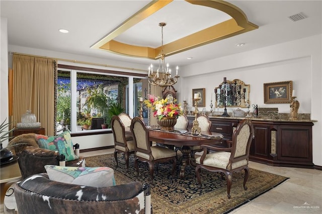 dining room with a tray ceiling, visible vents, baseboards, and an inviting chandelier