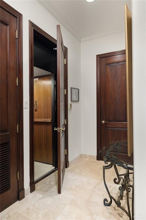 hallway featuring visible vents, crown molding, and baseboards