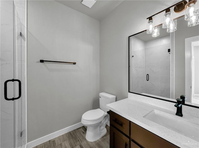 bathroom with wood-type flooring, toilet, a shower with shower door, and vanity