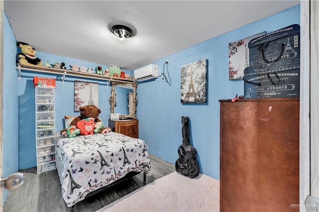 bedroom with wood-type flooring and an AC wall unit