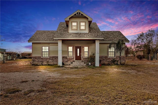 view of front of property featuring a lawn and a porch