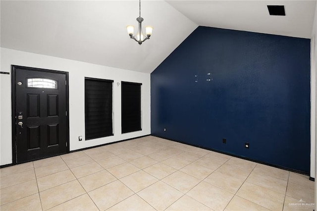 foyer featuring vaulted ceiling, light tile patterned floors, and an inviting chandelier