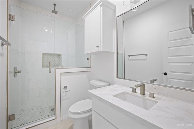 bathroom featuring vanity, toilet, and a shower with shower door