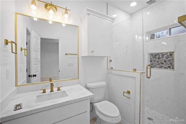 bathroom featuring vanity, toilet, and a shower with door