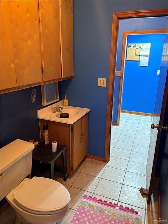 bathroom with tile patterned flooring, vanity, and toilet