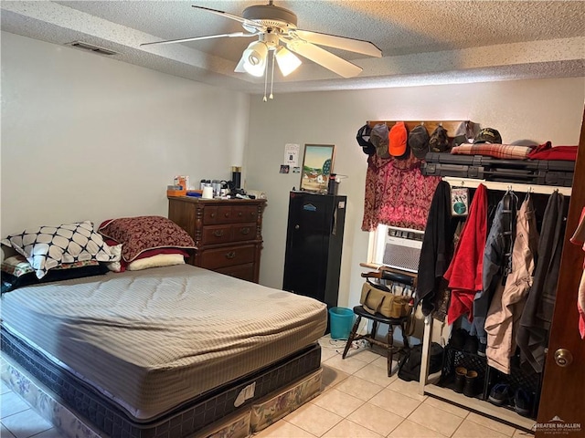 bedroom featuring light tile patterned floors, a textured ceiling, and ceiling fan