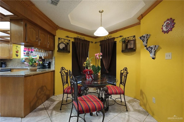 dining area with light tile patterned floors, a textured ceiling, and crown molding