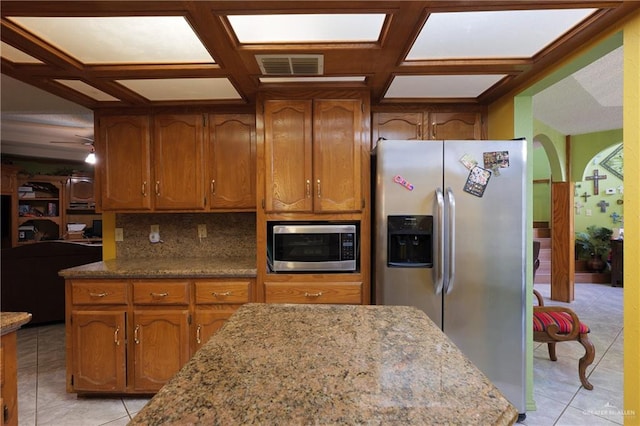 kitchen with light stone countertops, stainless steel appliances, tasteful backsplash, and coffered ceiling