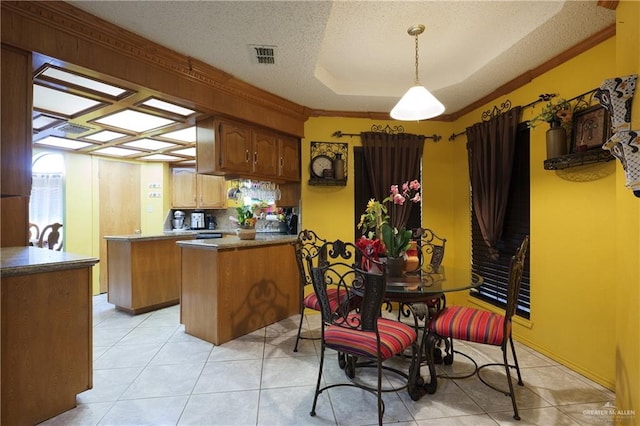 kitchen featuring a textured ceiling, crown molding, pendant lighting, light tile patterned floors, and a kitchen island