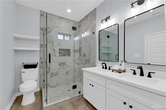 bathroom featuring an enclosed shower, vanity, and toilet