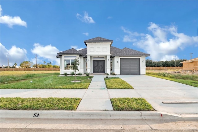 view of front of home with a front yard and a garage