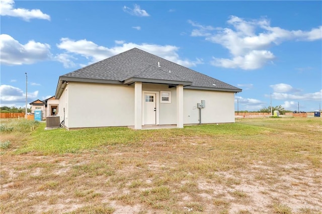 rear view of property with a yard and cooling unit