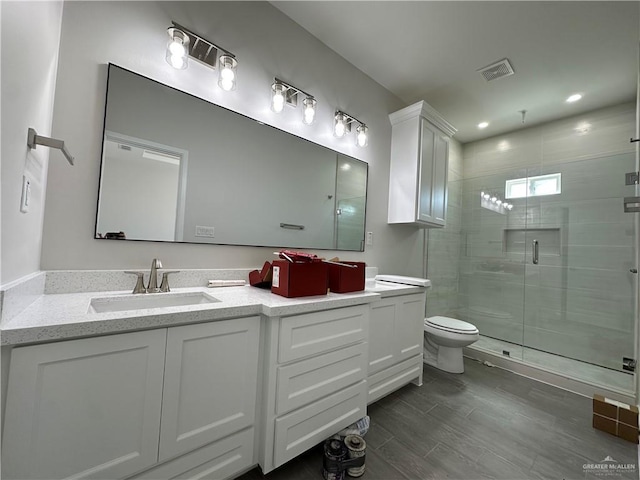 full bath featuring visible vents, toilet, a stall shower, and vanity