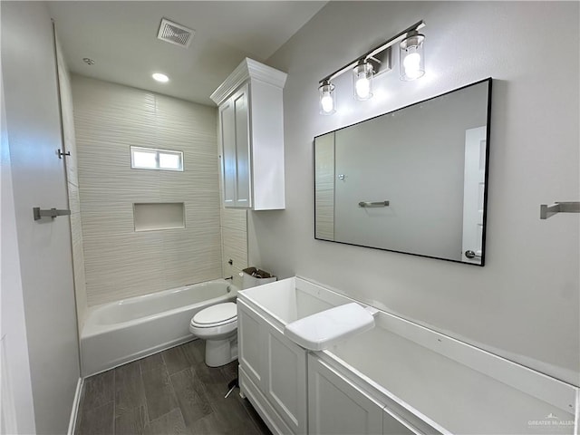 full bath with vanity, wood finished floors, visible vents, tub / shower combination, and toilet