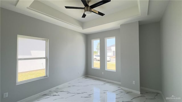 unfurnished room with a tray ceiling and ceiling fan