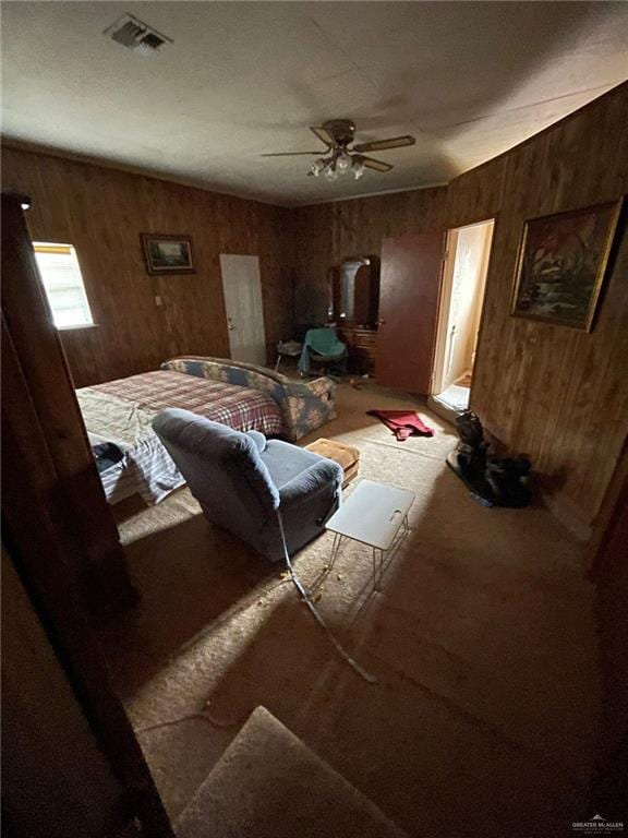 bedroom with ceiling fan and wood walls