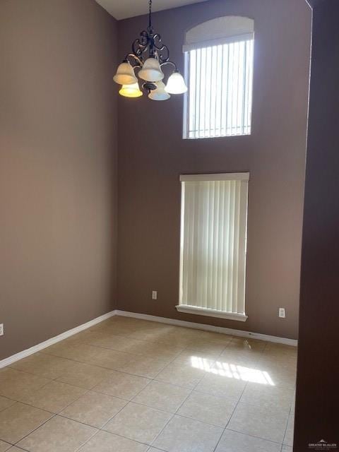 704 N Drennan St N, Edinburg, TX 78541 - unfurnished room with light tile patterned floors, a chandelier, baseboards, and a high ceiling
