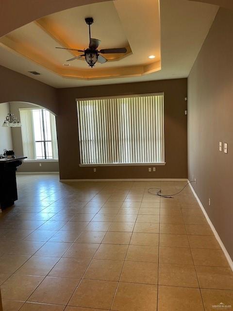 704 N Drennan St N, Edinburg, TX 78541 - unfurnished room with a tray ceiling, a ceiling fan, arched walkways, and tile patterned floors
