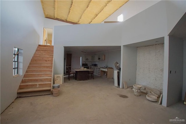 interior space featuring a towering ceiling and concrete flooring