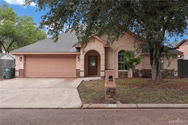 1507 Vatia Blvd, Mission, TX 78572 - mediterranean / spanish home featuring stucco siding, an attached garage, stone siding, and driveway