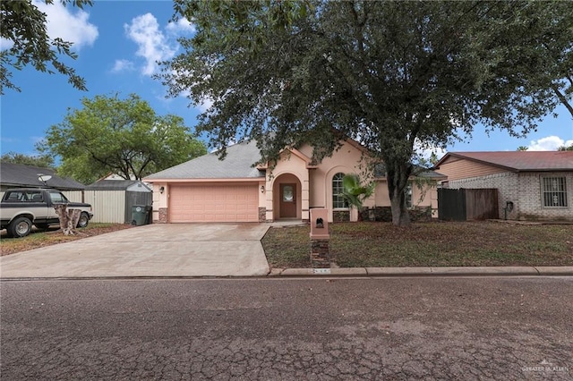 1507 Vatia Blvd, Mission, TX 78572 - view of front facade with a garage, stucco siding, concrete driveway, and a shed