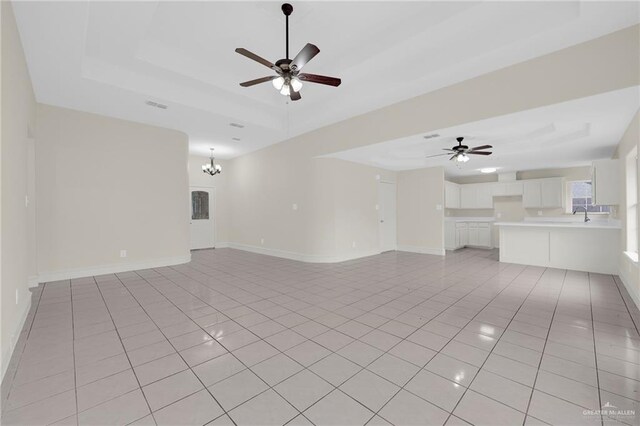 1507 Vatia Blvd, Mission, TX 78572 - unfurnished living room featuring a ceiling fan, light tile patterned floors, a chandelier, and a raised ceiling