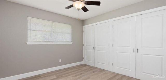 unfurnished bedroom featuring two closets, ceiling fan, and light wood-type flooring