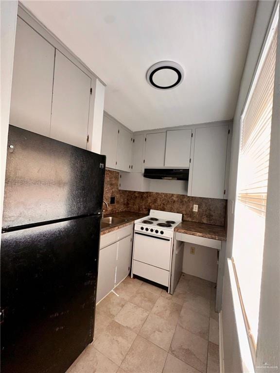 kitchen with black refrigerator, sink, tasteful backsplash, and white range with electric stovetop