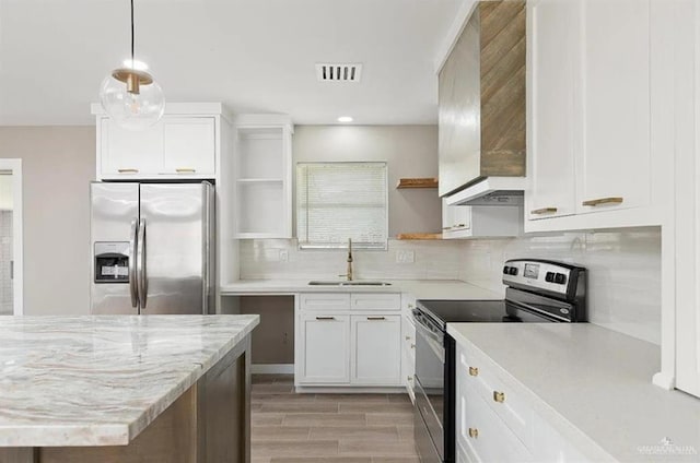 kitchen with sink, stainless steel appliances, white cabinets, decorative light fixtures, and exhaust hood