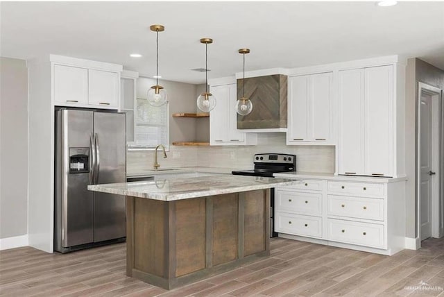 kitchen with white cabinetry, decorative light fixtures, appliances with stainless steel finishes, a kitchen island, and decorative backsplash