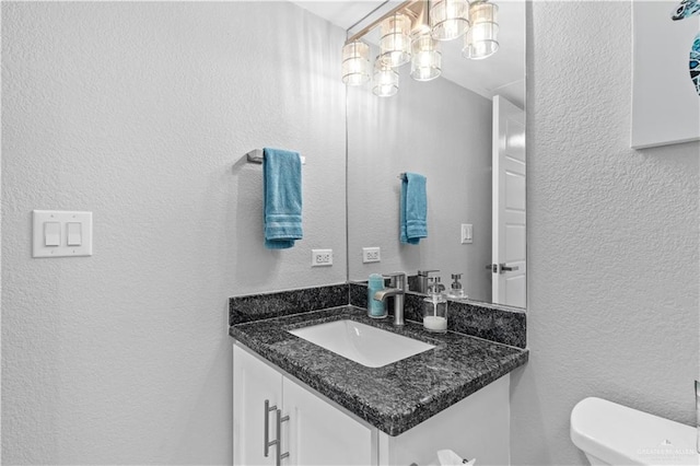 1000 Padre Blvd, South Padre Island, TX 78597 - bathroom featuring a textured wall, vanity, toilet, and a chandelier