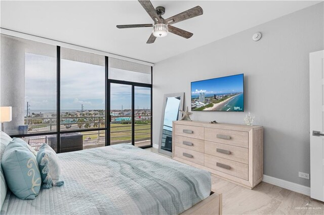 1000 Padre Blvd, South Padre Island, TX 78597 - bedroom with baseboards, a wall of windows, and a ceiling fan