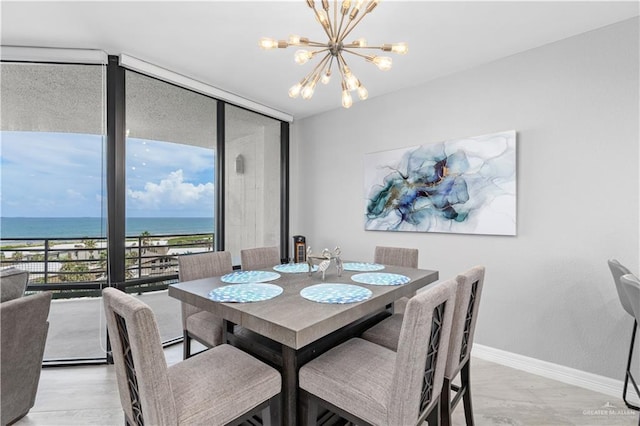 dining area featuring a water view, floor to ceiling windows, a notable chandelier, and light hardwood / wood-style floors