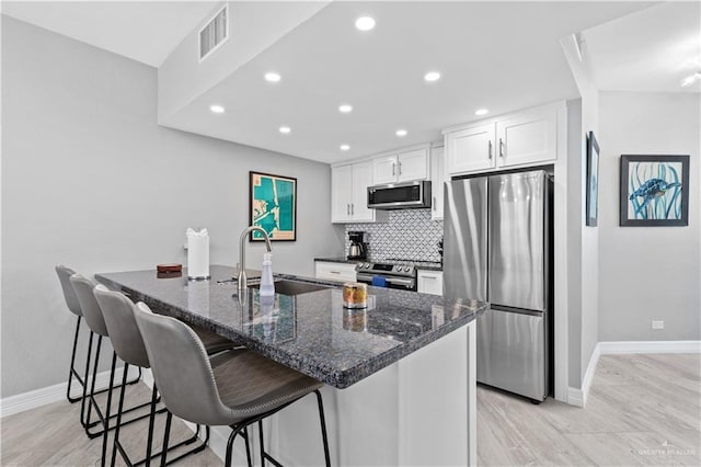 1000 Padre Blvd, South Padre Island, TX 78597 - kitchen featuring appliances with stainless steel finishes, a sink, baseboards, recessed lighting, and white cabinetry