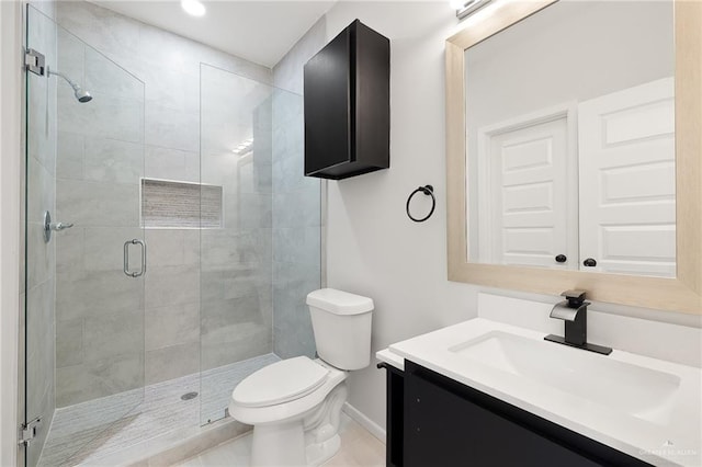 bathroom featuring a shower with door, vanity, and toilet