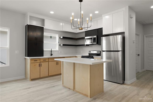 kitchen with sink, a center island, light wood-type flooring, pendant lighting, and stainless steel appliances