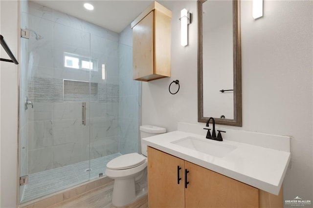 bathroom featuring vanity, wood-type flooring, toilet, and walk in shower