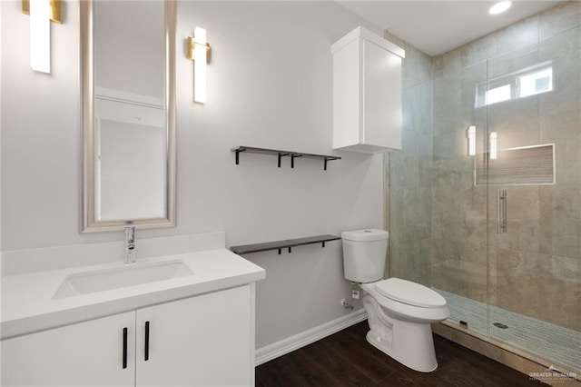 bathroom featuring vanity, hardwood / wood-style floors, a shower with shower door, and toilet