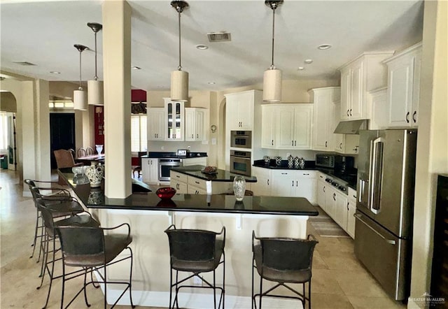 kitchen with white cabinets, appliances with stainless steel finishes, and hanging light fixtures