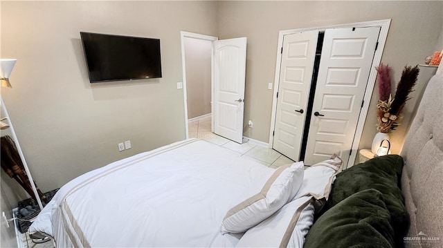 bedroom with light tile patterned floors and a closet