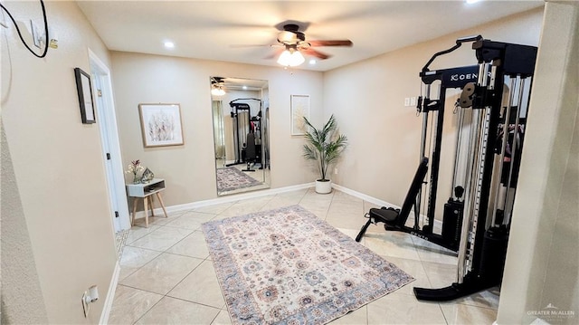 exercise area with ceiling fan and light tile patterned floors